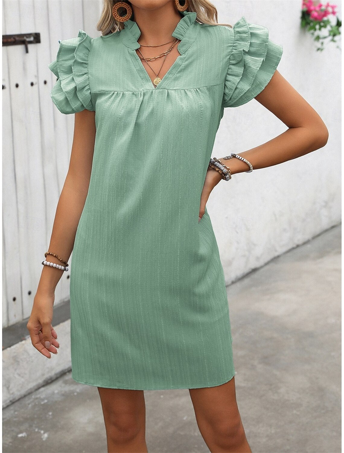 Woman wearing a plain A-line V-neck mini dress, front view.