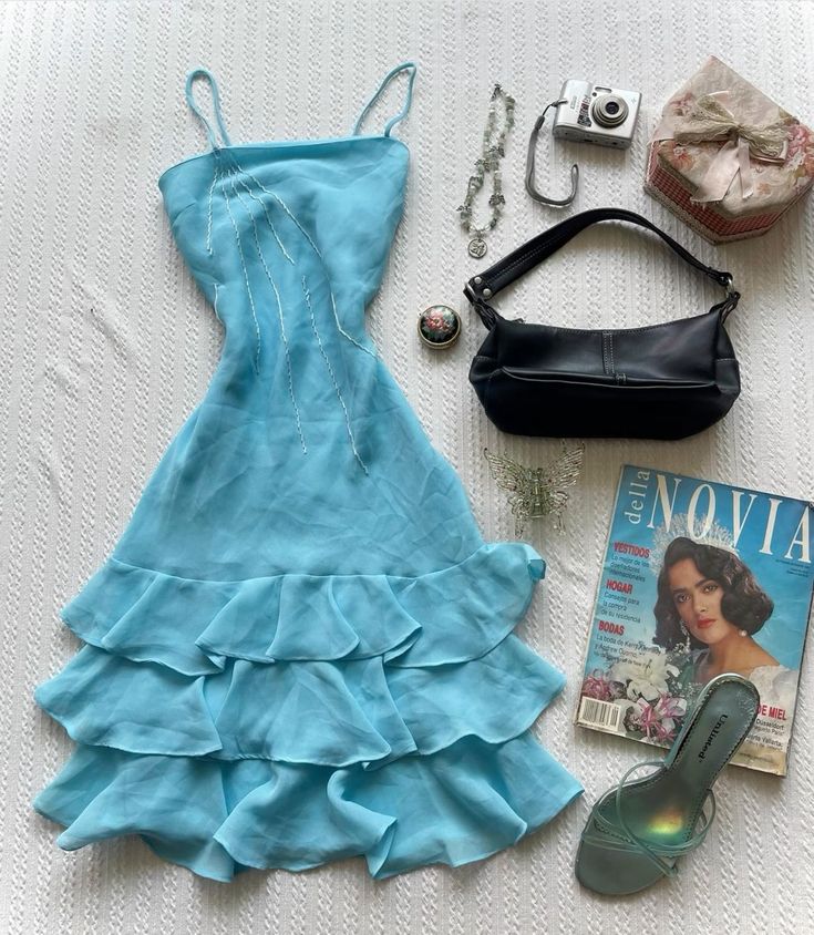 Young woman wearing a short blue A-line homecoming dress with spaghetti straps and ruffles.