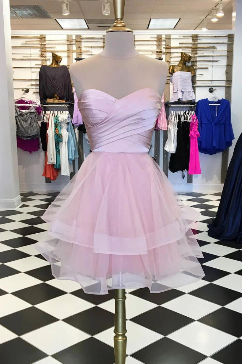 Model wearing a charming pink tulle short prom dress with an A-line silhouette.
