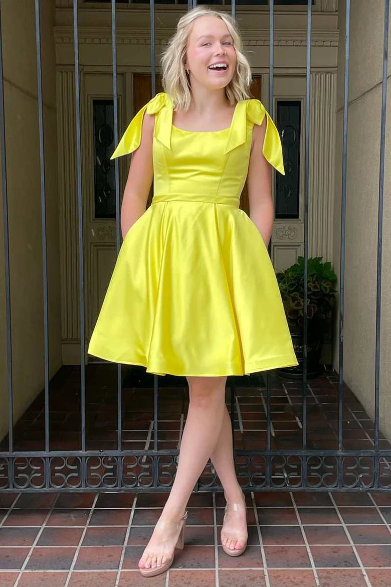 Yellow A-line short homecoming dress with square neckline and bow-straps.