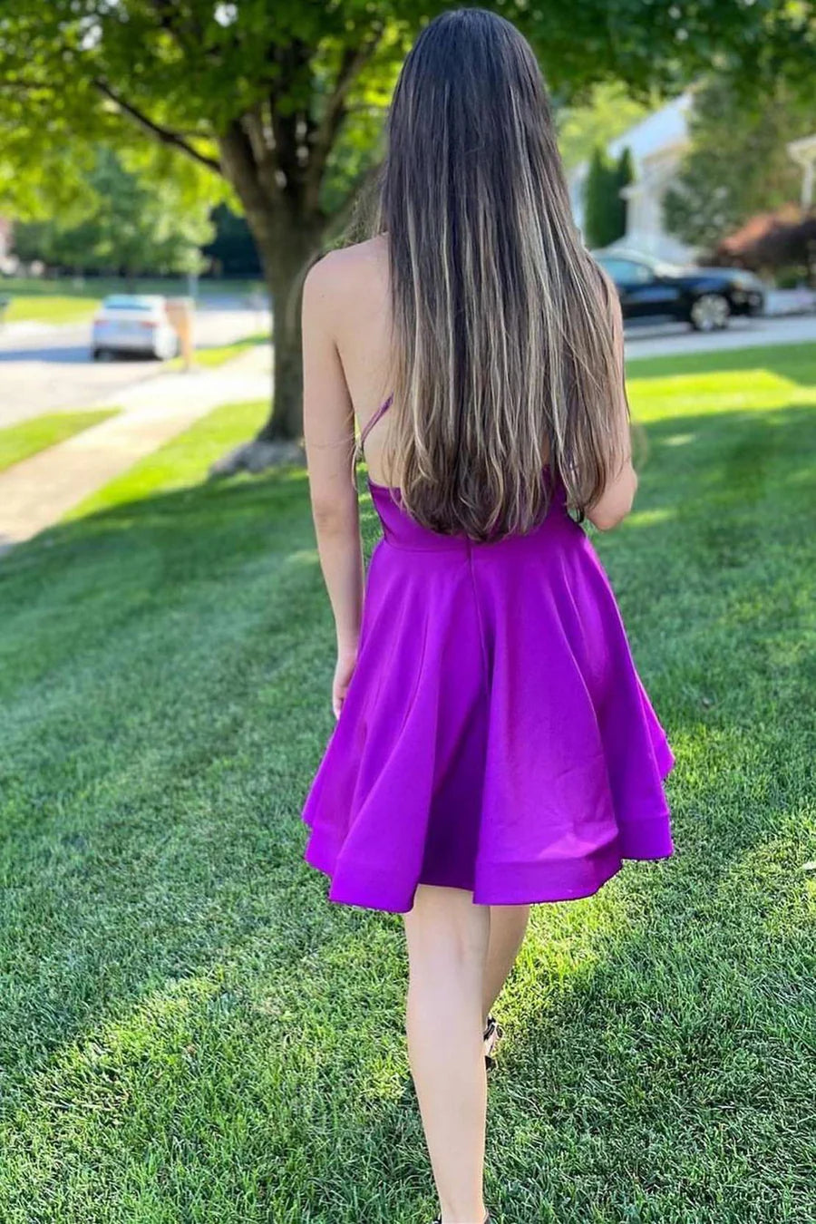 Back view of a model in a purple lace-up A-line homecoming dress.