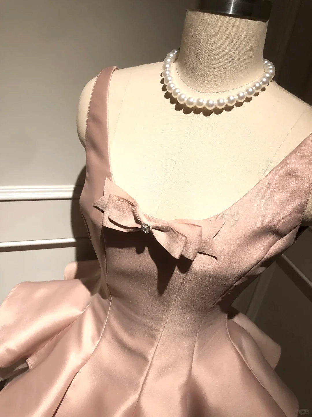 Close-up of light pink tulle and satin fabric on homecoming dress.
