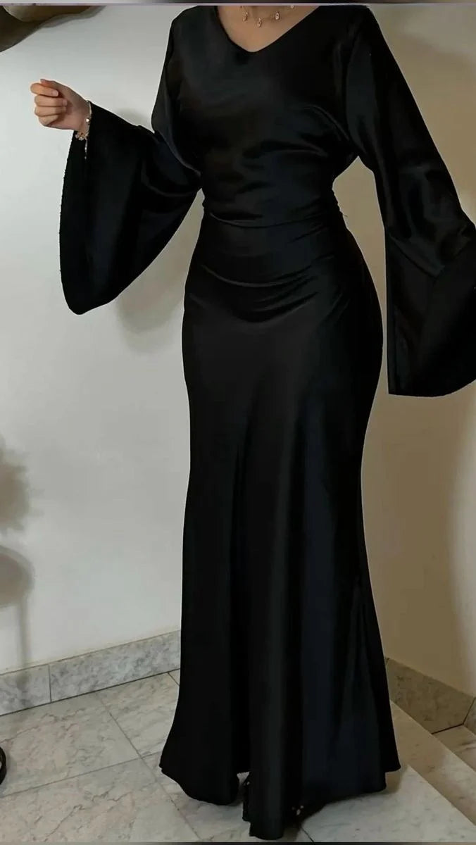 Woman wearing an elegant vintage black satin long evening dress.