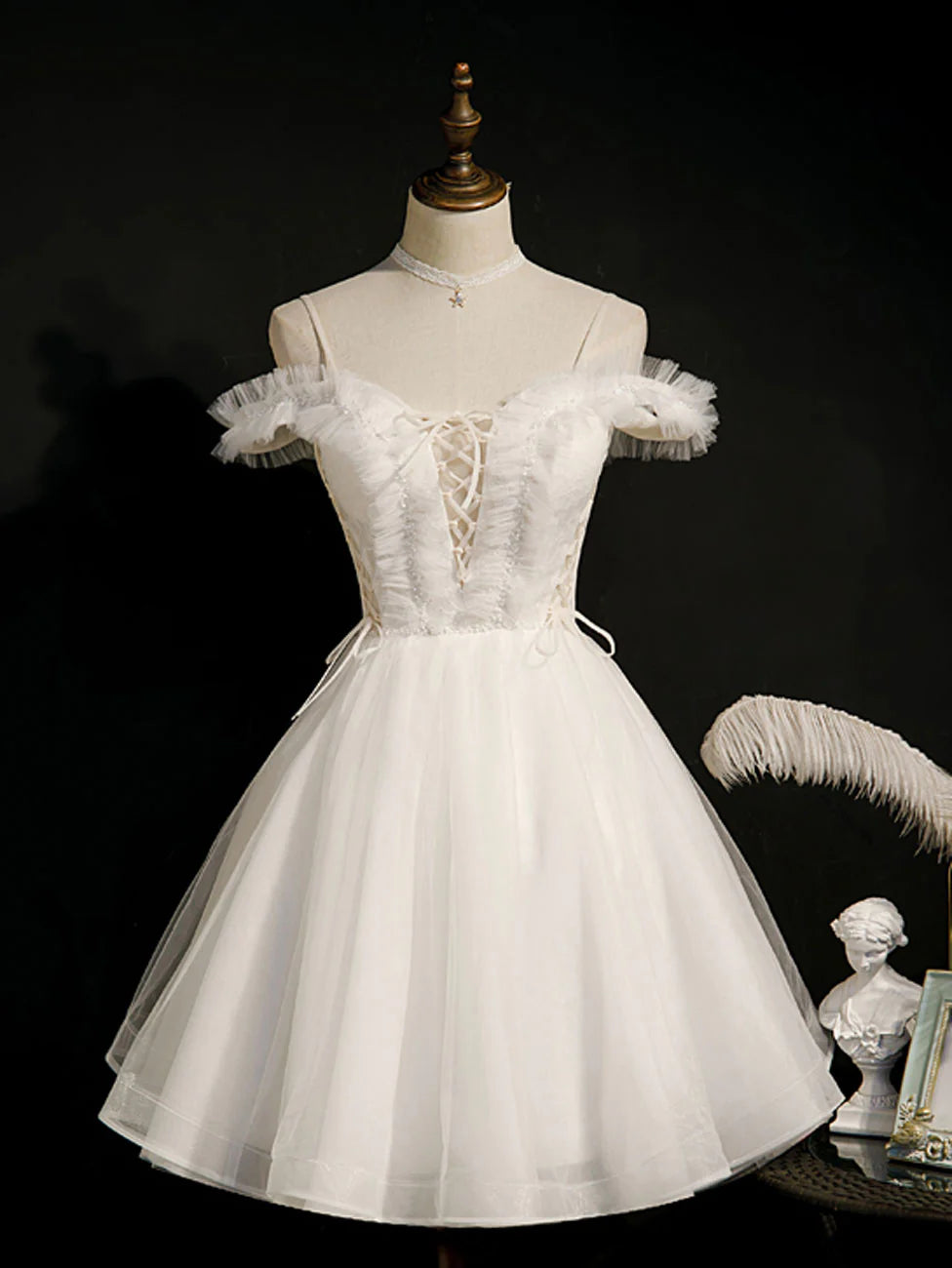 Front view of a model wearing a charming white short puffy homecoming dress.