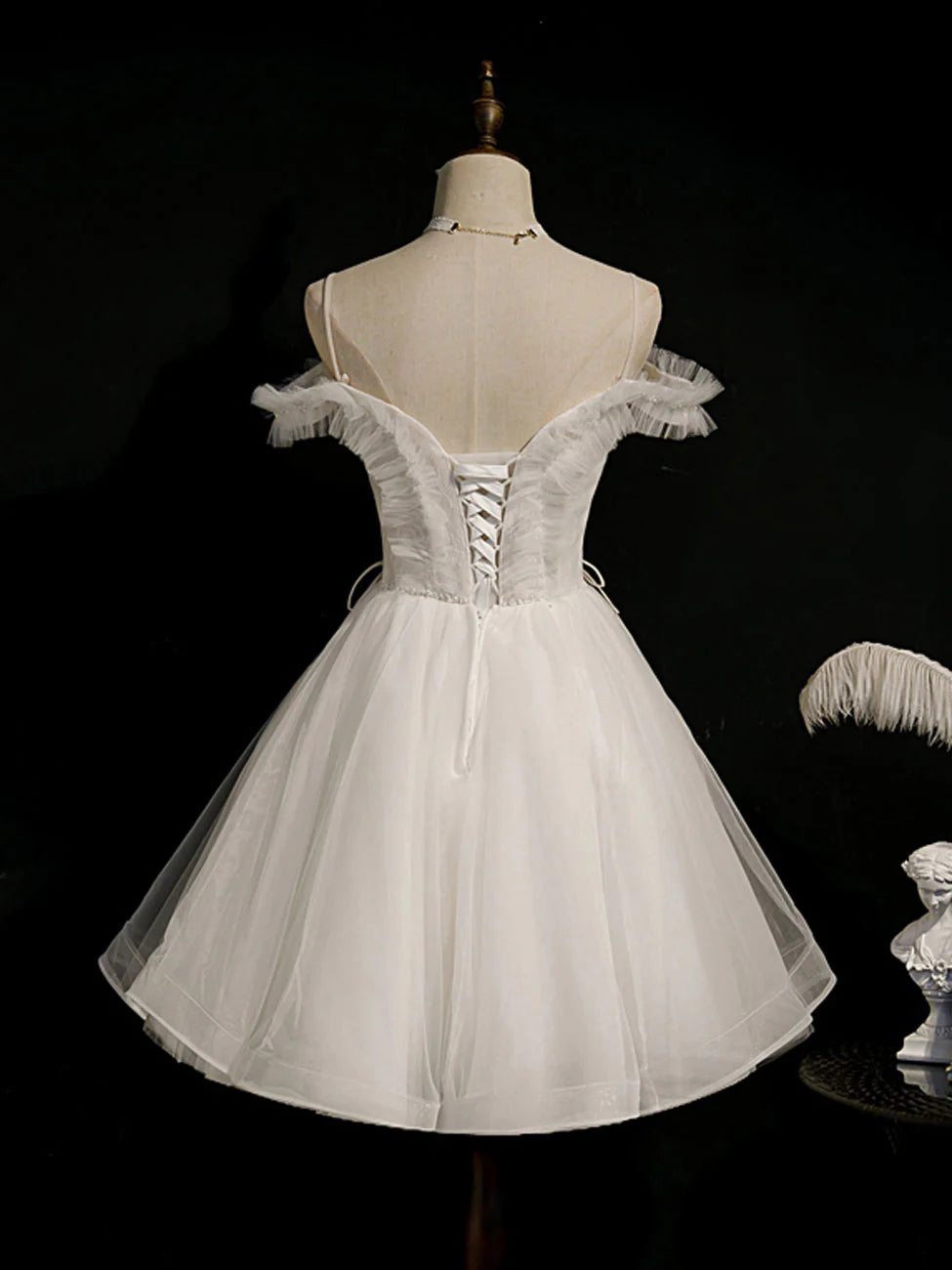 Back view of a model showcasing a white short puffy party dress.