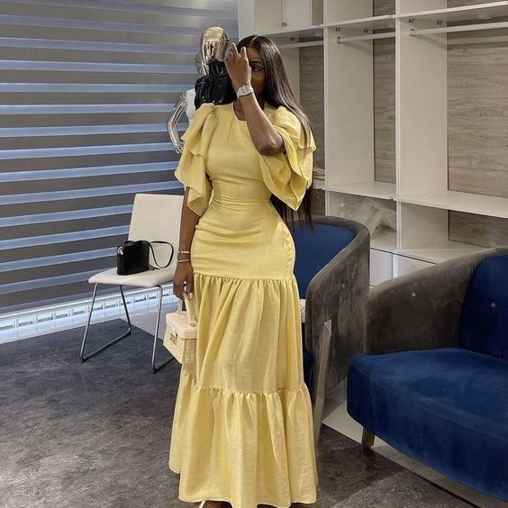 Woman wearing a charming yellow long slim-fit formal evening gown.