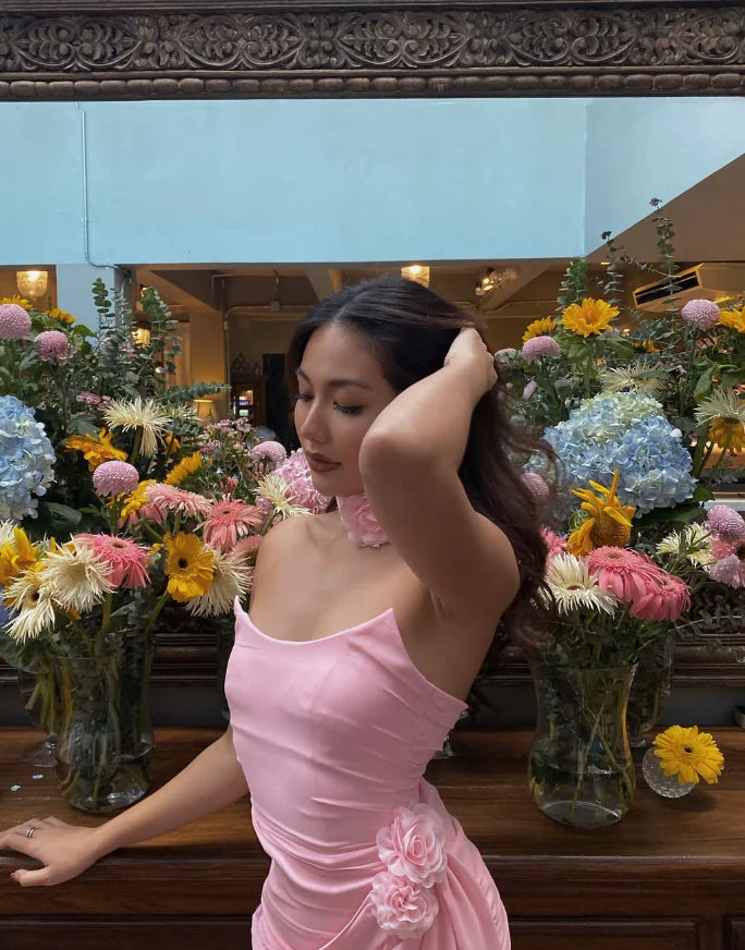 Side profile of a pink strapless dress, showcasing 3D flowers and short length.