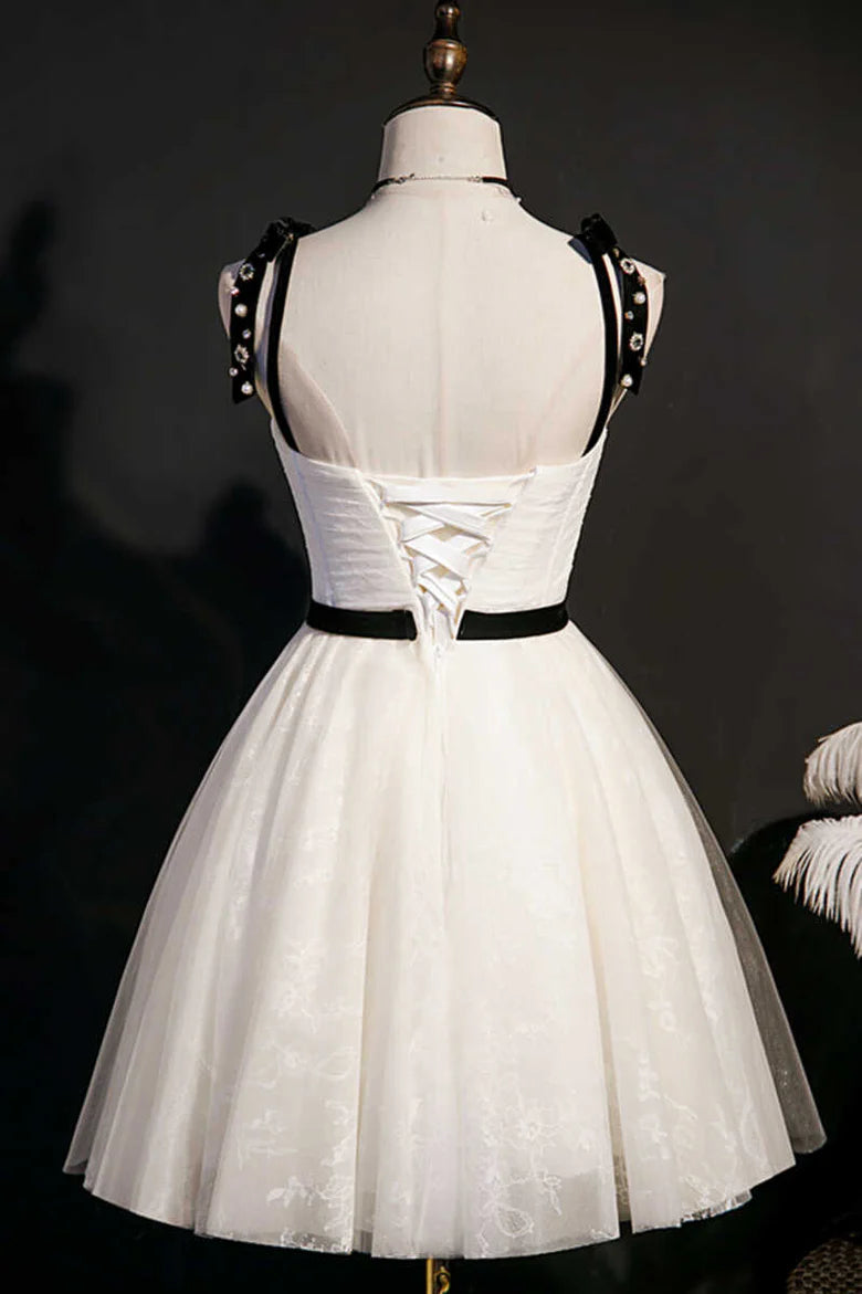 Back view of the beige A-line homecoming dress, highlighting the backless design and bow straps.