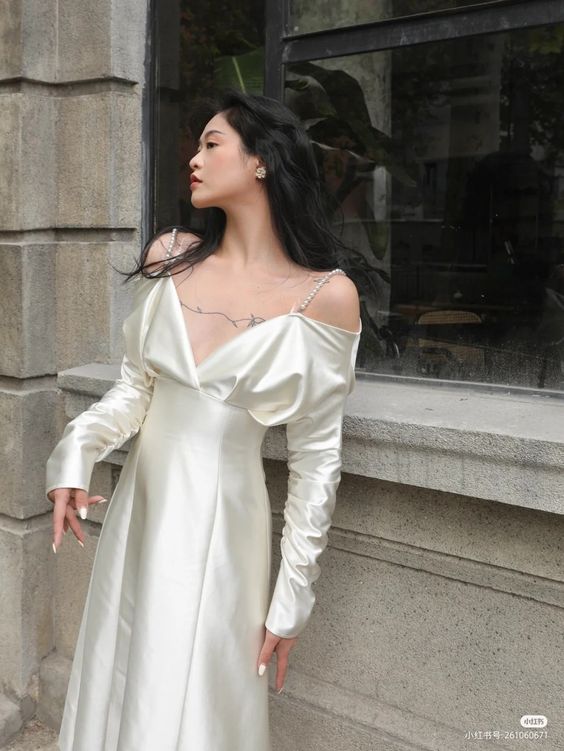 Woman wearing an elegant ivory vintage evening party dress.