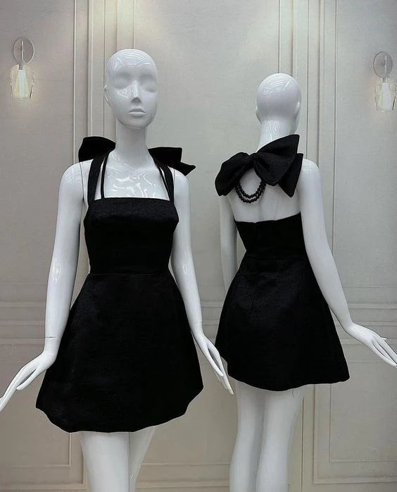 Woman wearing a chic satin A-line mini homecoming dress with square neck, halter, and bow detail.
