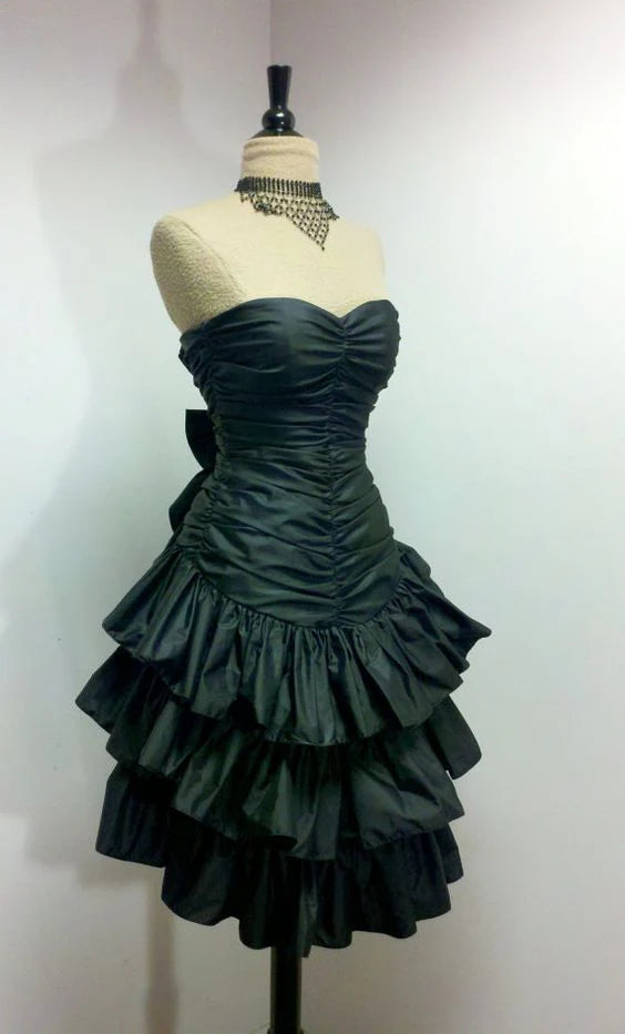 Front view of a dark green strapless short party dress with a ruffle hem.