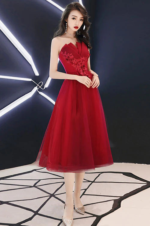 Model wearing a burgundy A-line short prom dress with tulle and lace details.