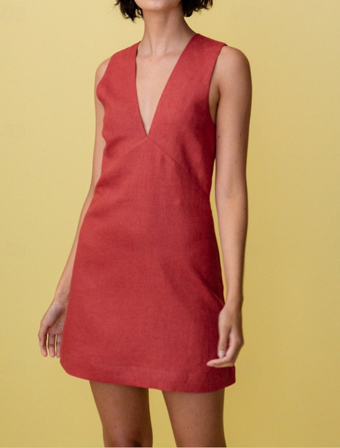 Woman wearing a pure color A-line V-neck sleeveless mini dress, front view.