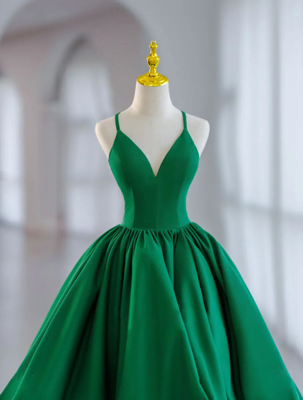 Side view of a model showcasing a short green satin ball gown prom dress.