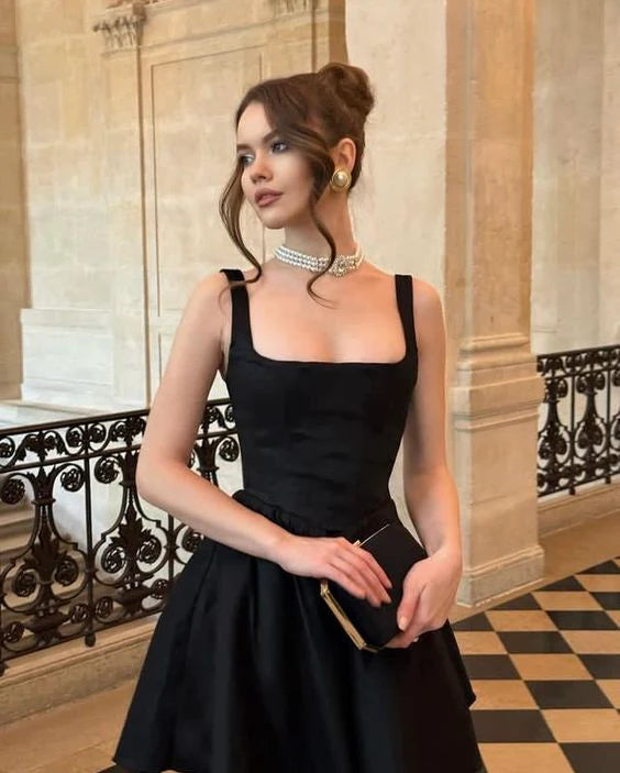 Stylish black party dress featuring a modern square neckline and short length.