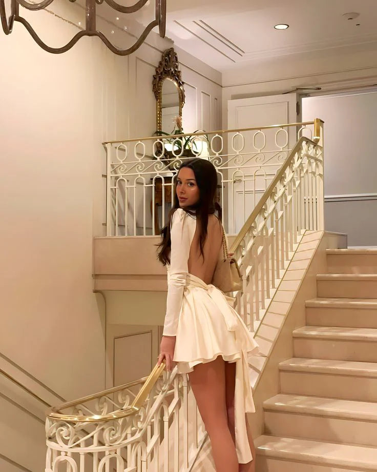 Side view of a woman in a white fitted party dress.