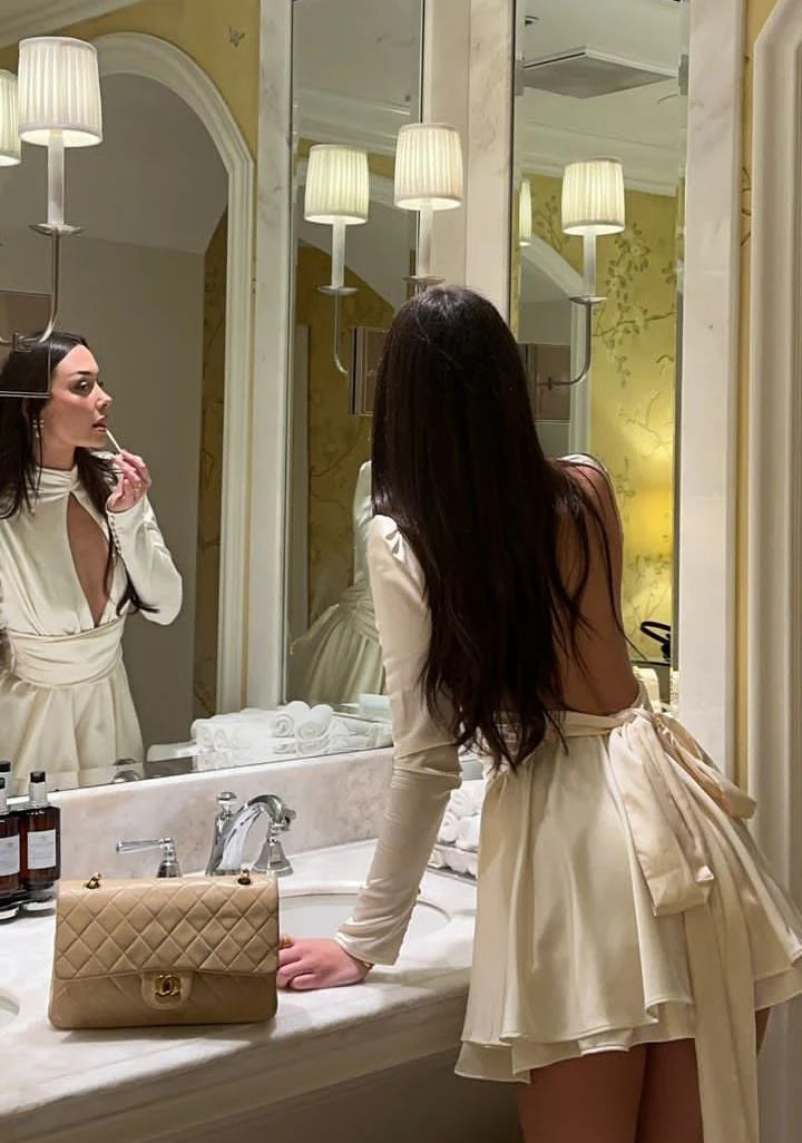Full length view of a woman in an elegant white mini dress.