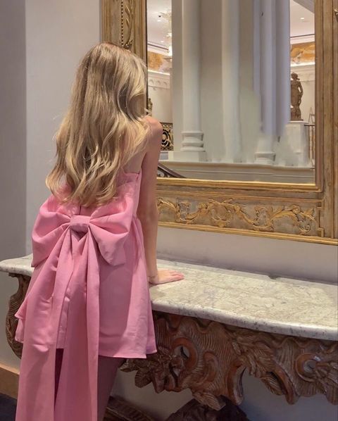 Close-up of the back of a pink satin homecoming dress, highlighting the elegant bowknot.