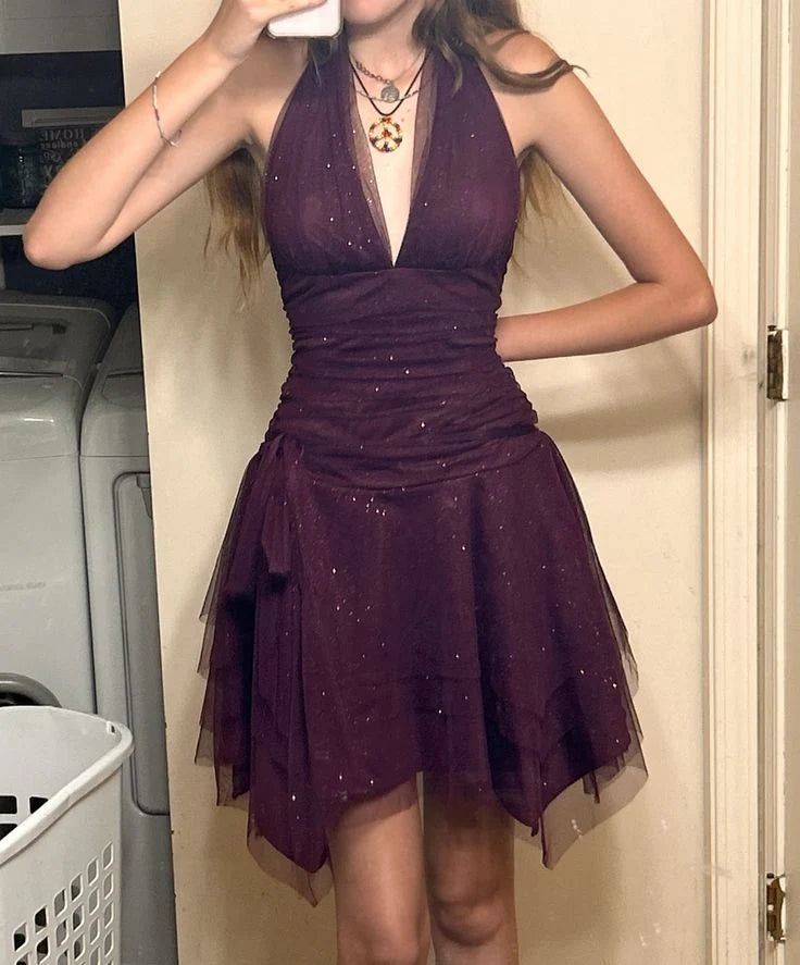 Dark purple halter neck homecoming dress with pleated bodice and flowing tulle skirt.