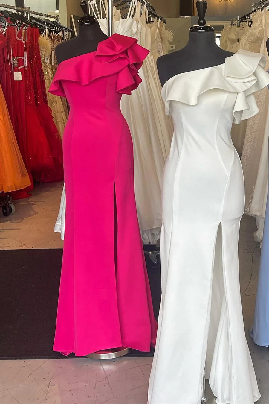 Elegant one-shoulder ruffled mermaid gown with a high slit, worn by a model.