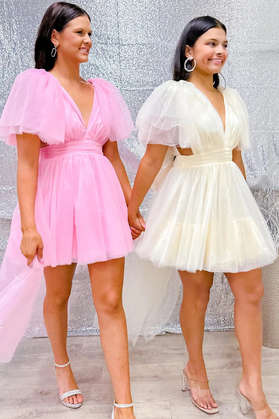 Front view of a model wearing a pink plunge V A-line homecoming dress with flutter sleeves.