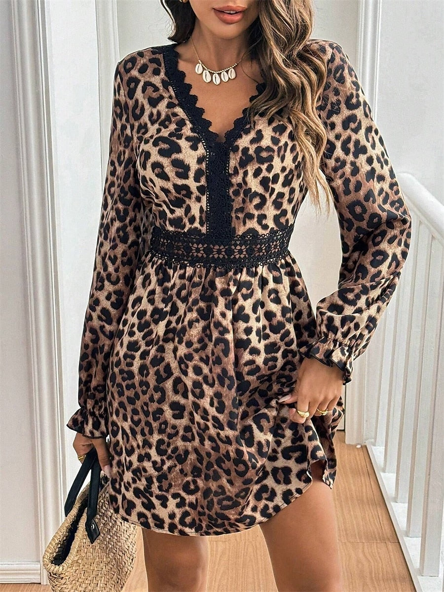 Woman wearing a chic V-neck leopard print maxi dress with long sleeves, posing elegantly.