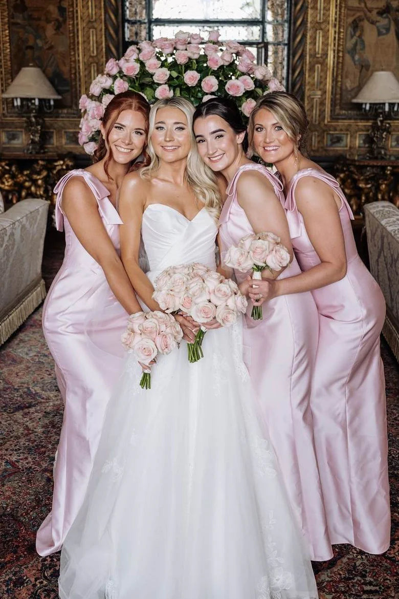 Back view of the long pink satin bridesmaid dress, highlighting the double straps and bow details.