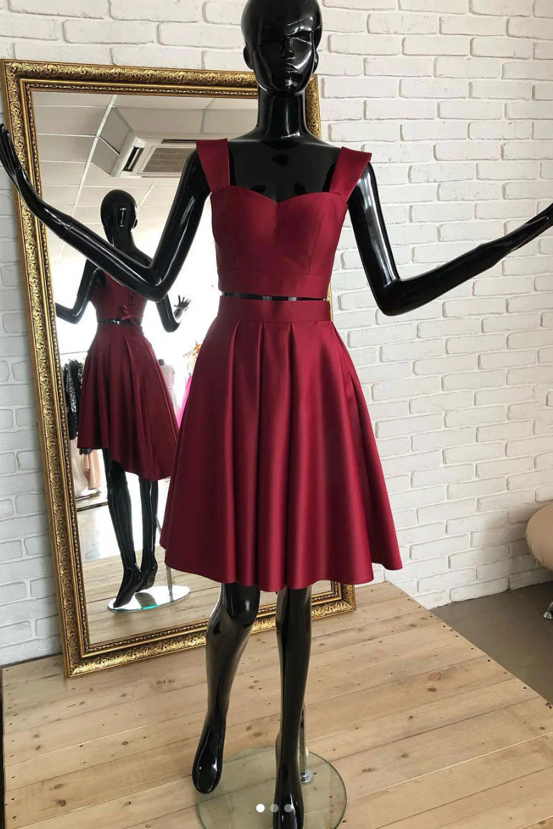 Model wearing a chic burgundy two-piece short prom dress, front view.