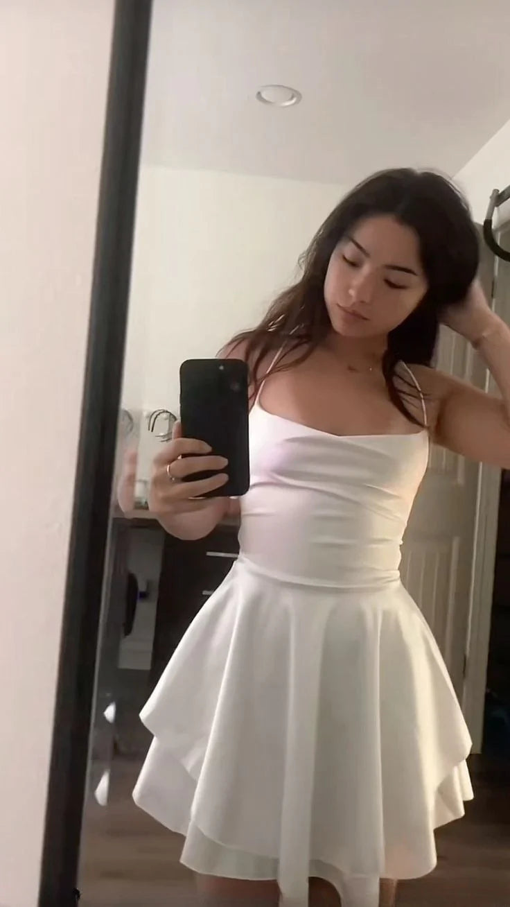 Model wearing a chic white A-line short homecoming dress with spaghetti straps and a lace-up back.