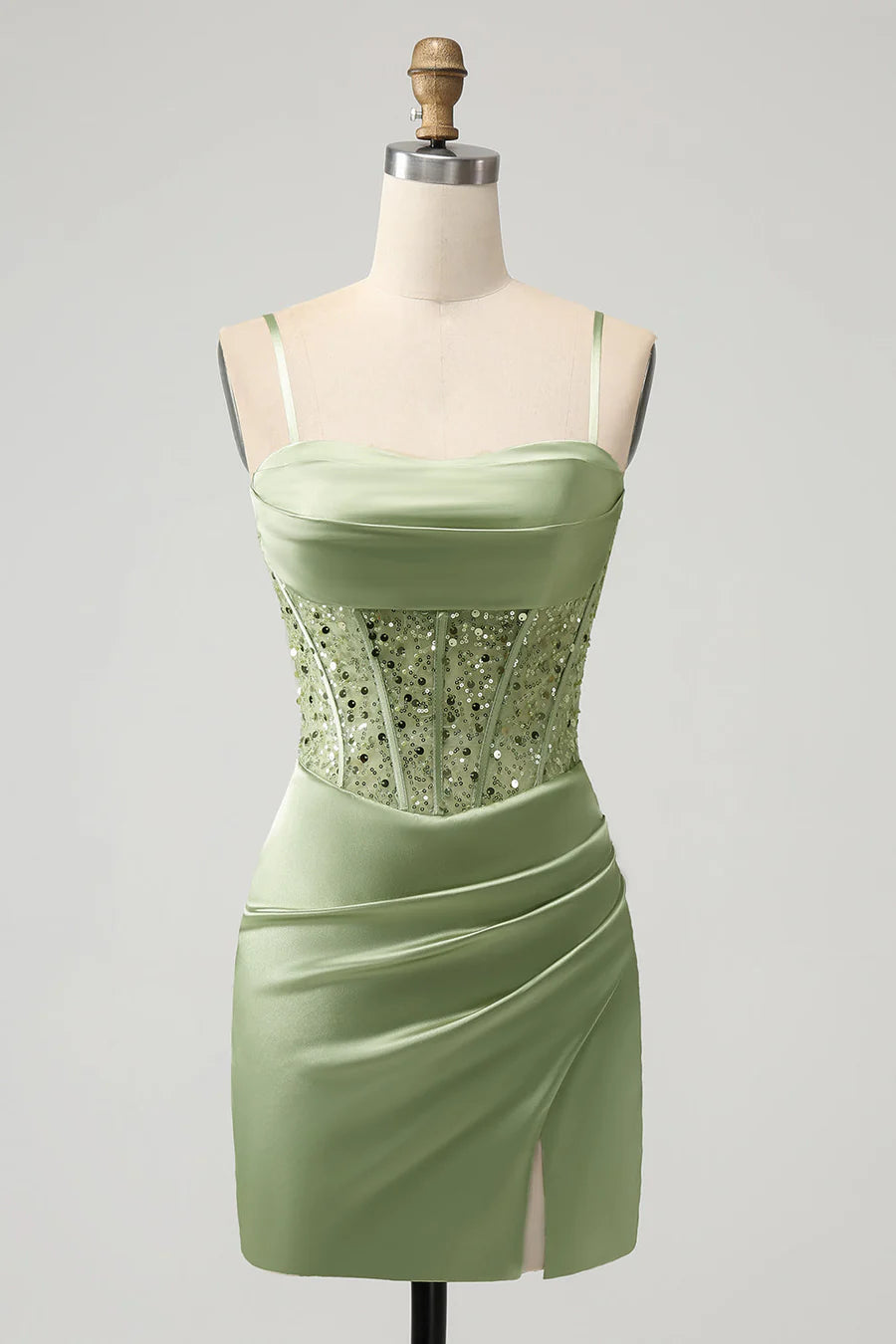 Model wearing a sage green sequin mini homecoming dress with delicate spaghetti straps and a corset bodice.