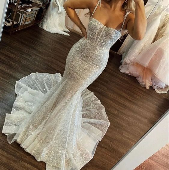 Full-length ivory sequined mermaid wedding dress with spaghetti straps.