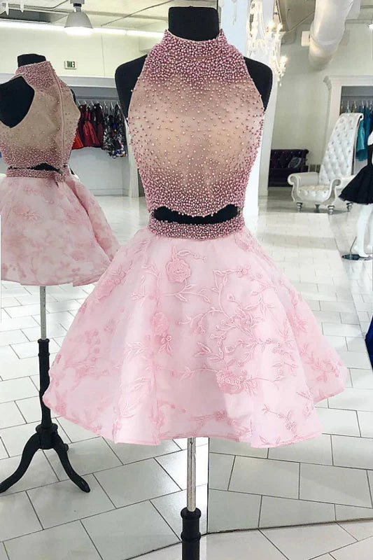 Model wearing a pink two-piece beaded lace short prom dress.