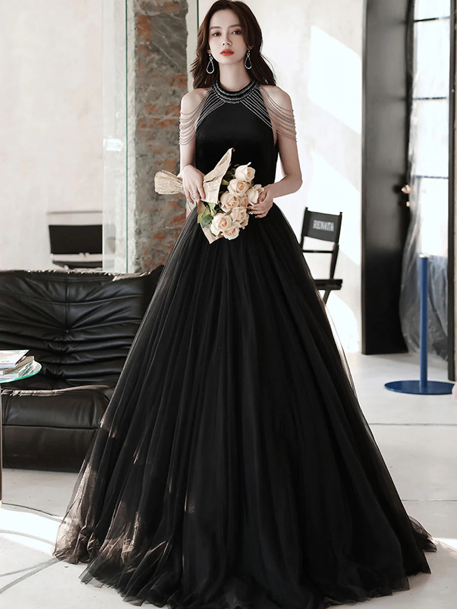 Model wearing a black A-line tulle beaded long prom dress.