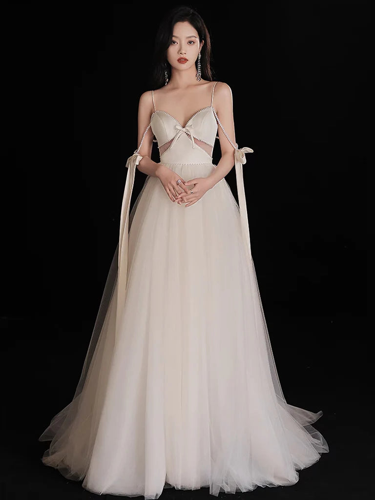 Full view of an A-Line light champagne tulle prom dress with delicate bead embellishments.