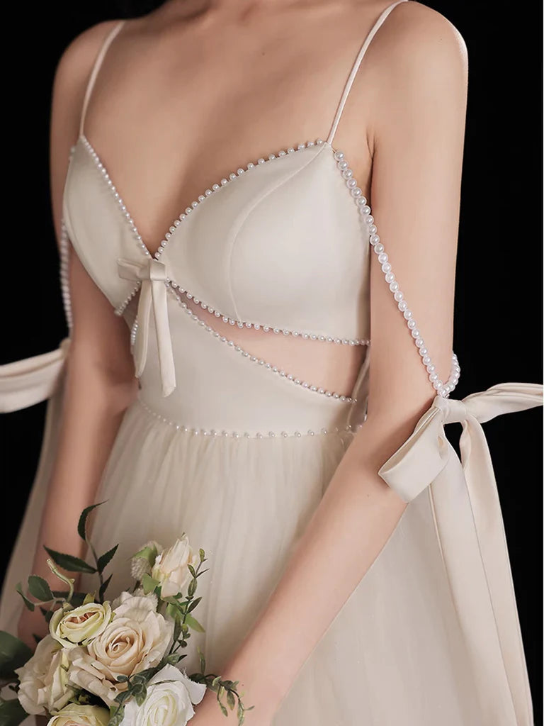 Side view of the flowing A-Line skirt and beaded details on the light champagne dress.