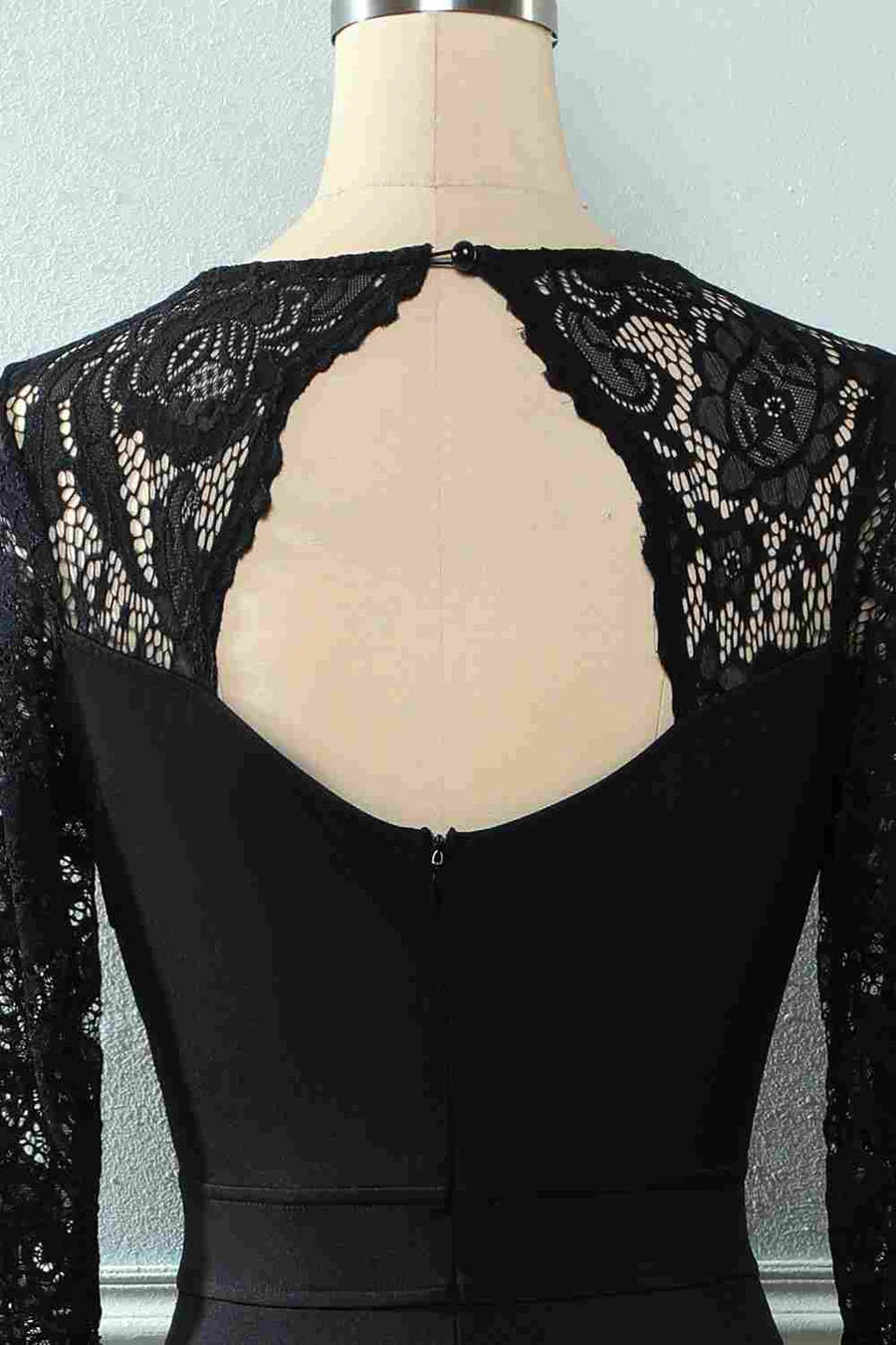Close-up of the intricate black lace fabric and V-neckline on the dress.