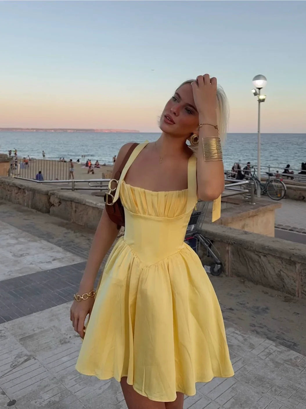 Flowy yellow cocktail party dress with delicate bow details.
