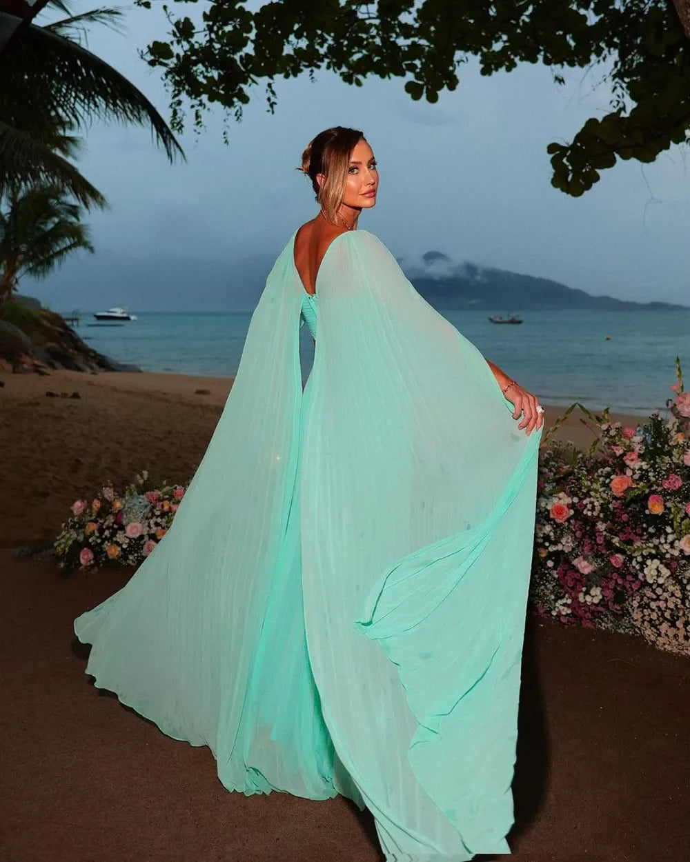 Full view of the mint green A-line chiffon formal evening gown with long cape sleeves.