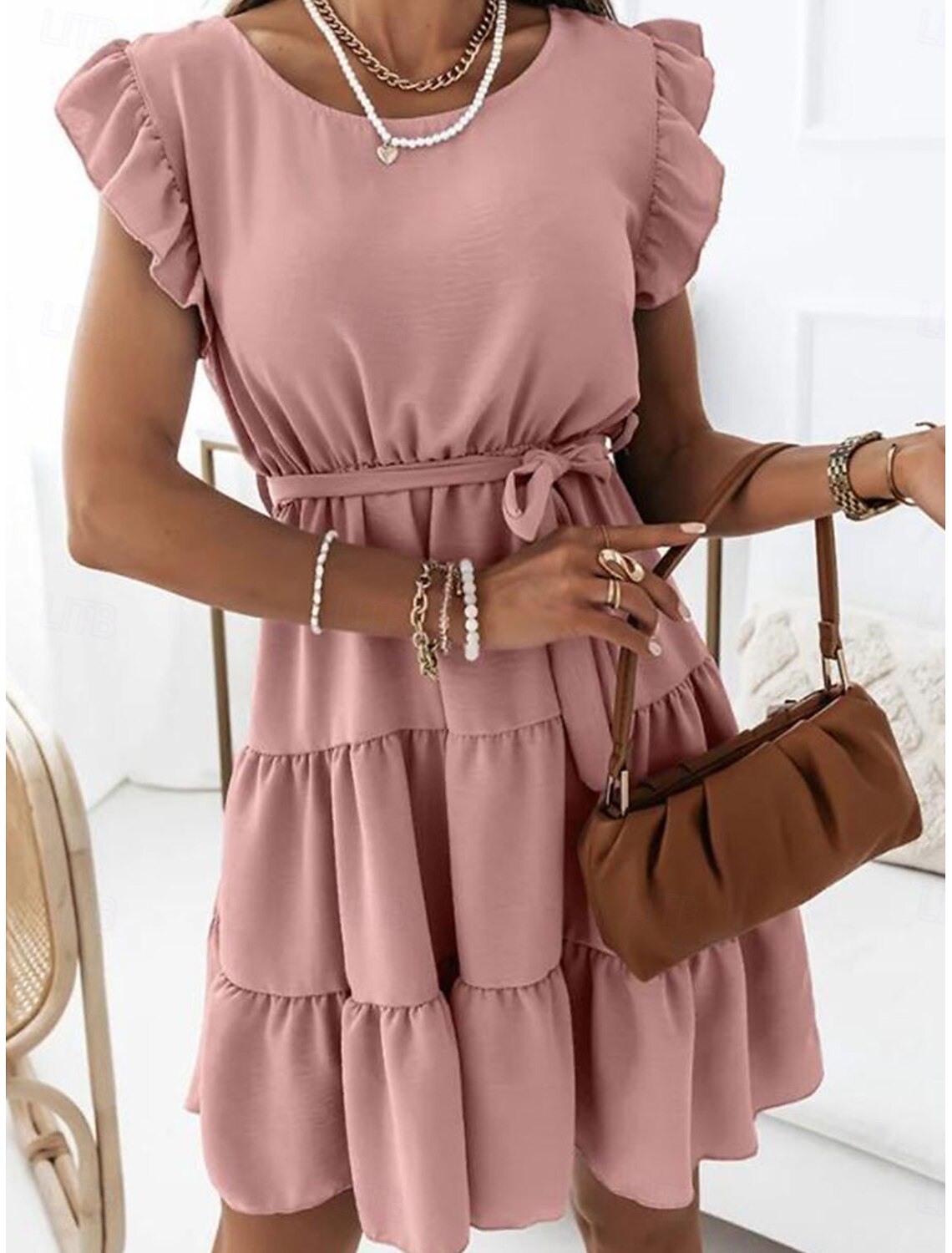 Side view of a woman wearing the stylish A-line mini dress.