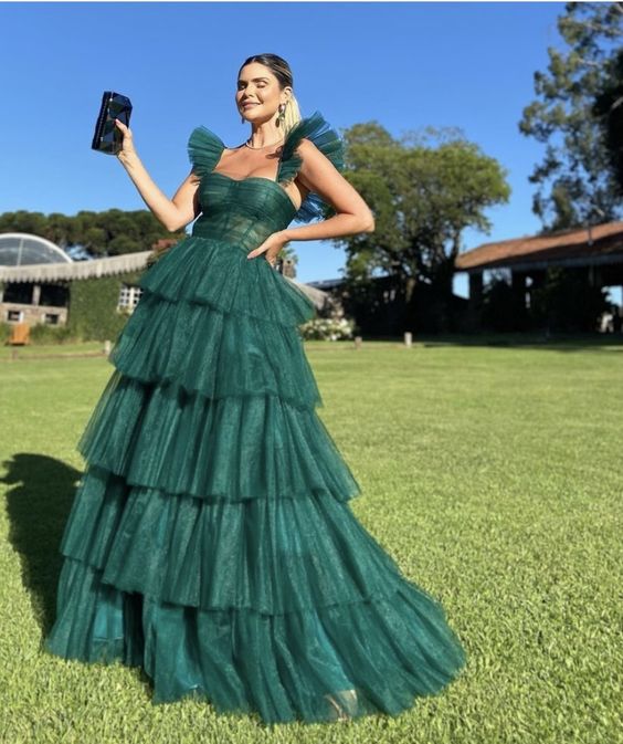 Model wearing a dark green A-line long prom dress with a fitted waist.