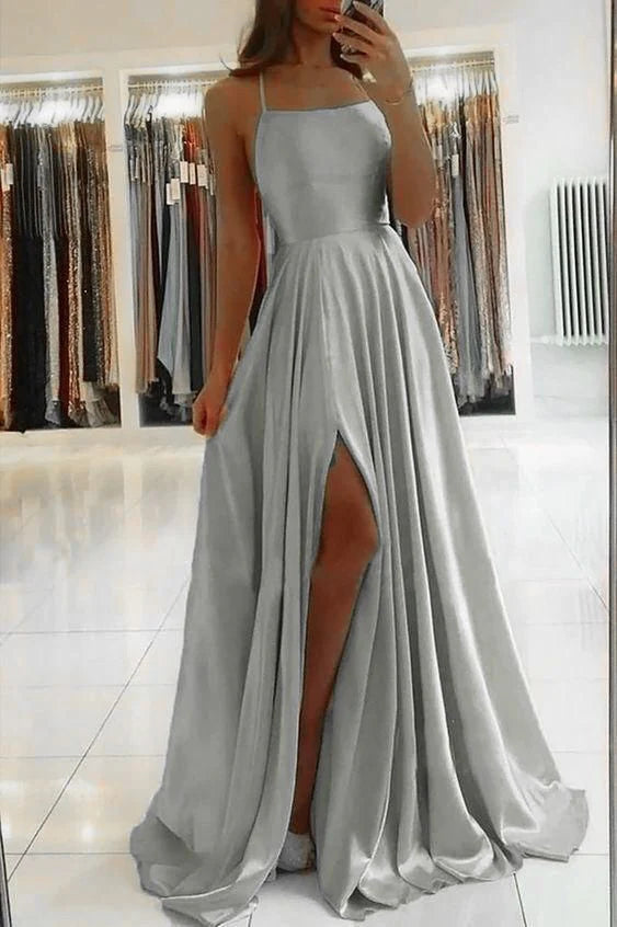 Full length view of a woman in a long satin formal evening dress.