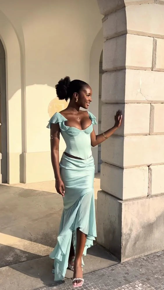 Woman wearing an elegant green satin sleeveless floor-length prom dress.