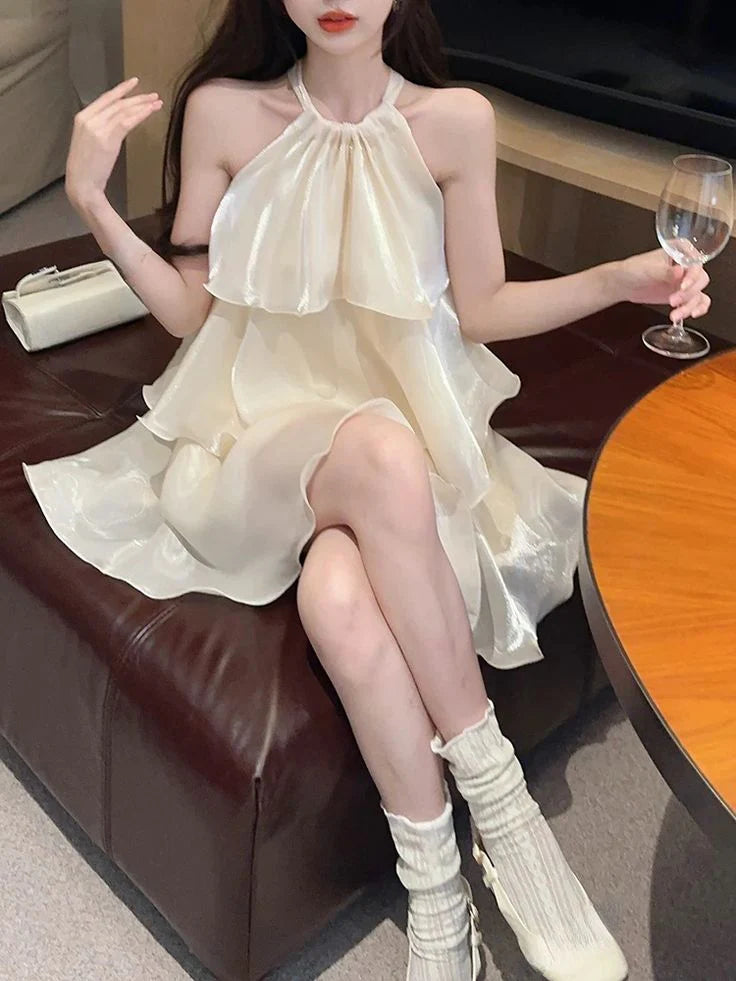 Light champagne satin short homecoming dress with a halter neckline and layered A-line skirt.