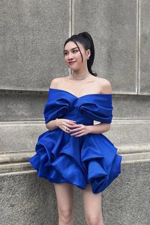 Model wearing an elegant blue off-shoulder mini homecoming dress, side view.