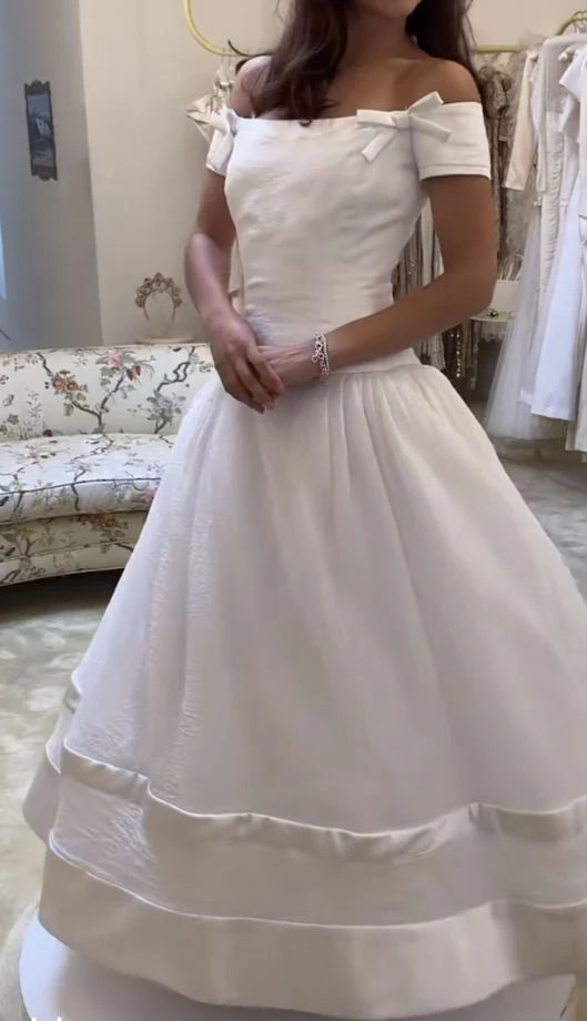 Model wearing an elegant A-line off-shoulder long wedding dress.