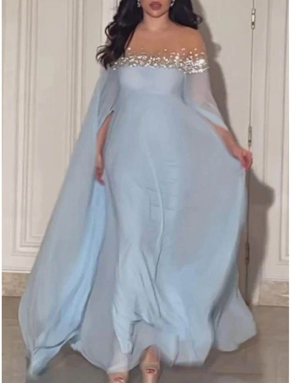 Woman posing in a stylish blue A-line off-shoulder maxi dress.