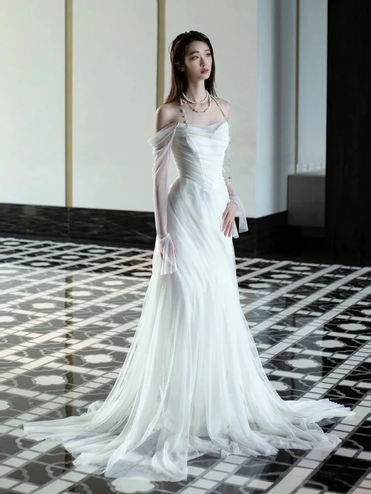Side view of a model wearing the elegant off-shoulder white wedding gown.