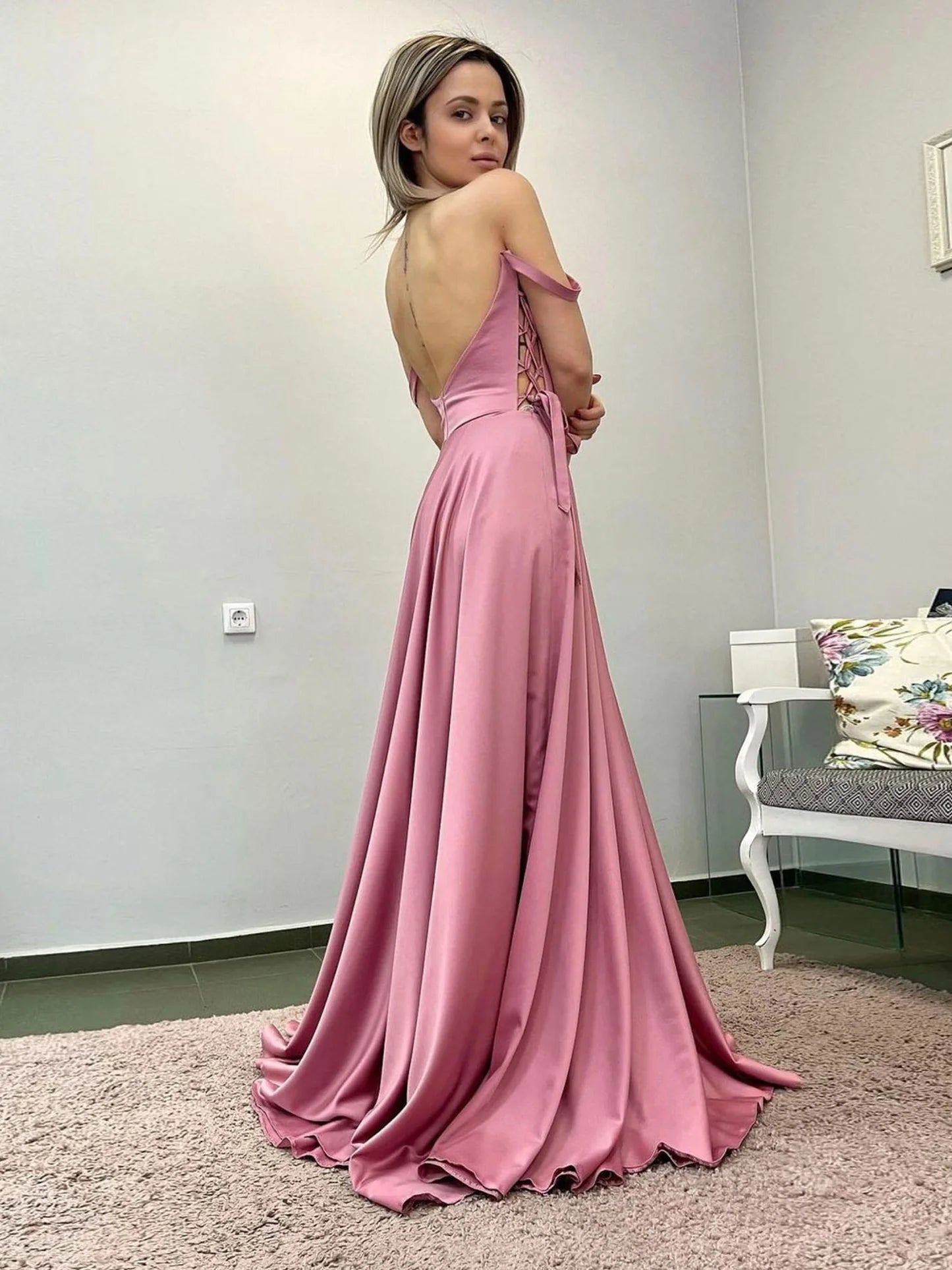 Woman wearing a long pink satin evening gown.