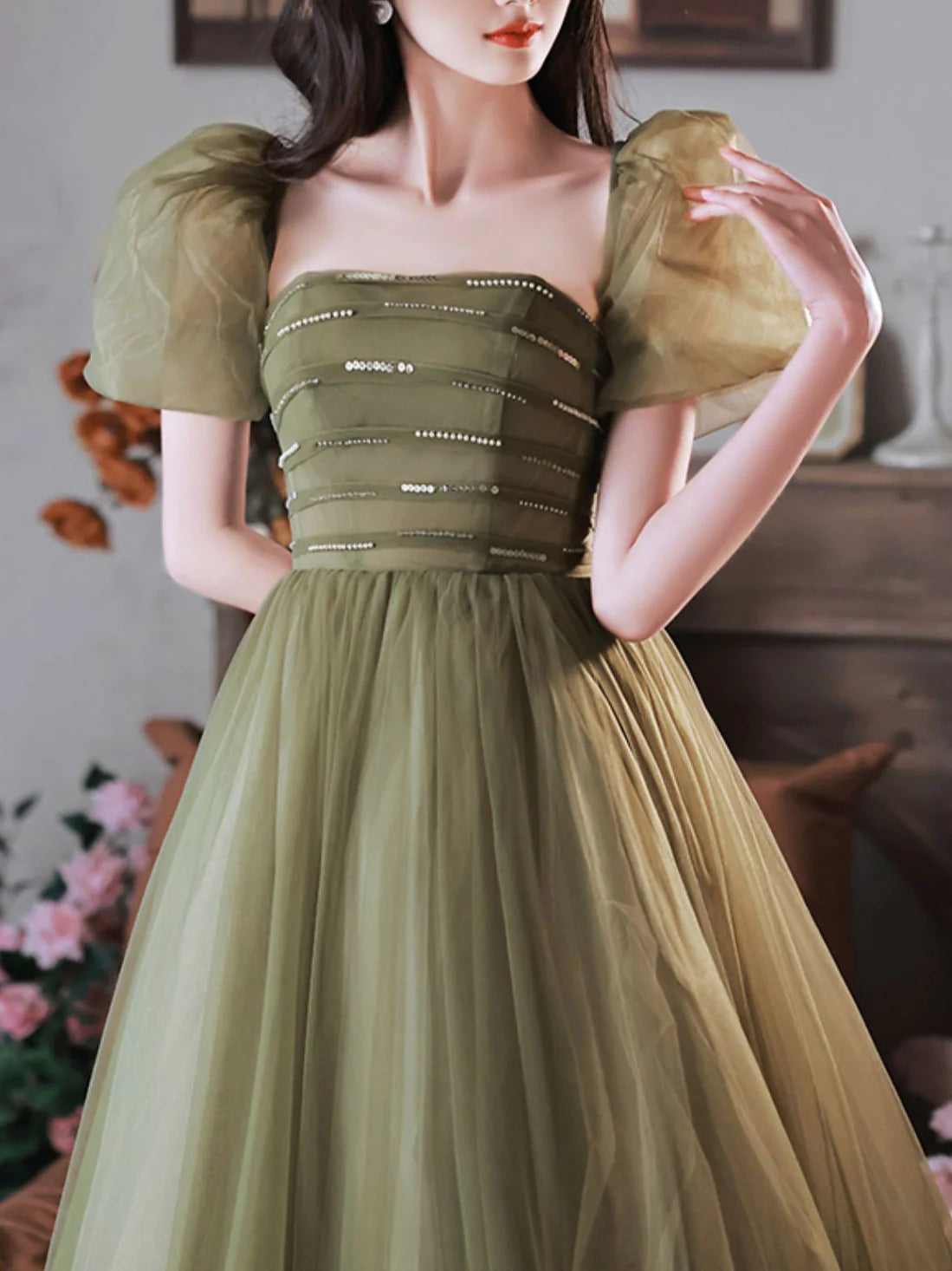 Model wearing an elegant A-line green sequin tulle off-shoulder long prom dress, posing gracefully.