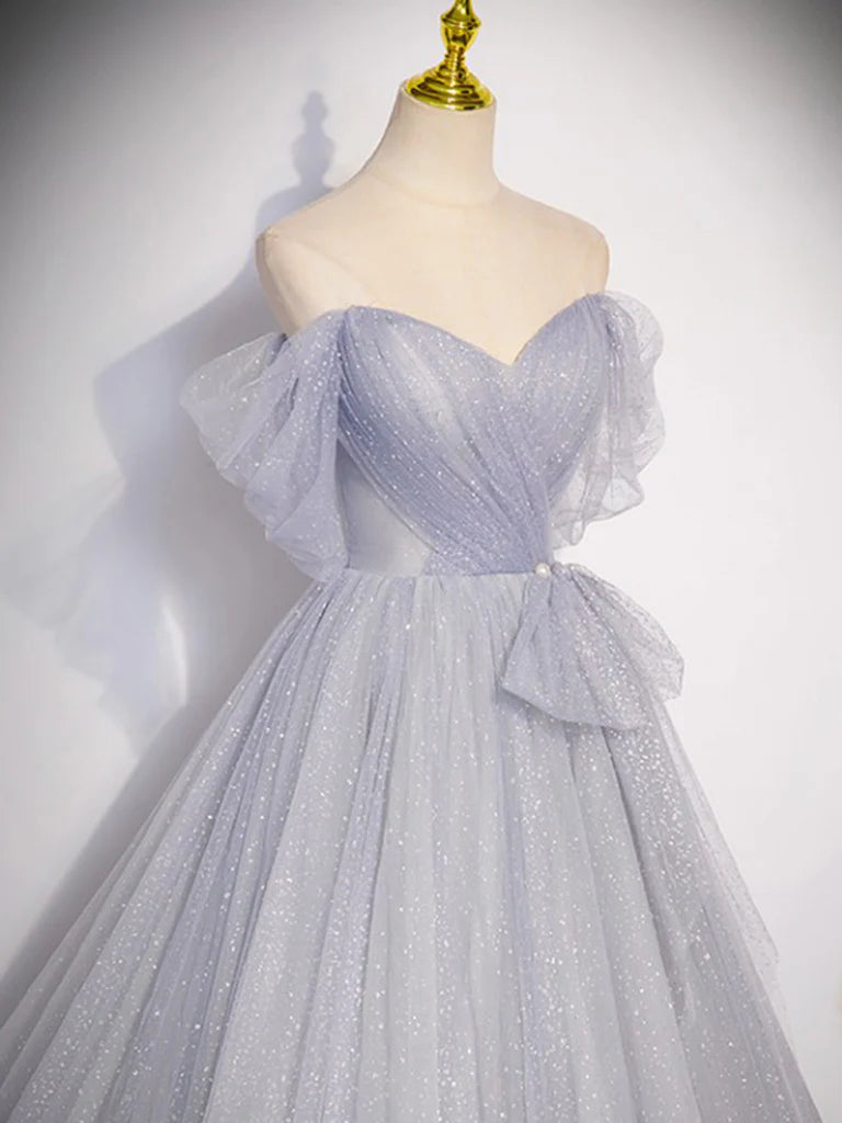 Side view of a woman wearing a gray A-line formal gown.